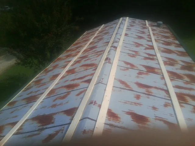 Rusted metal roof panels with new wood purlins before replacement — Storm Damage Roof Repair in Kechi by Roofing Brothers