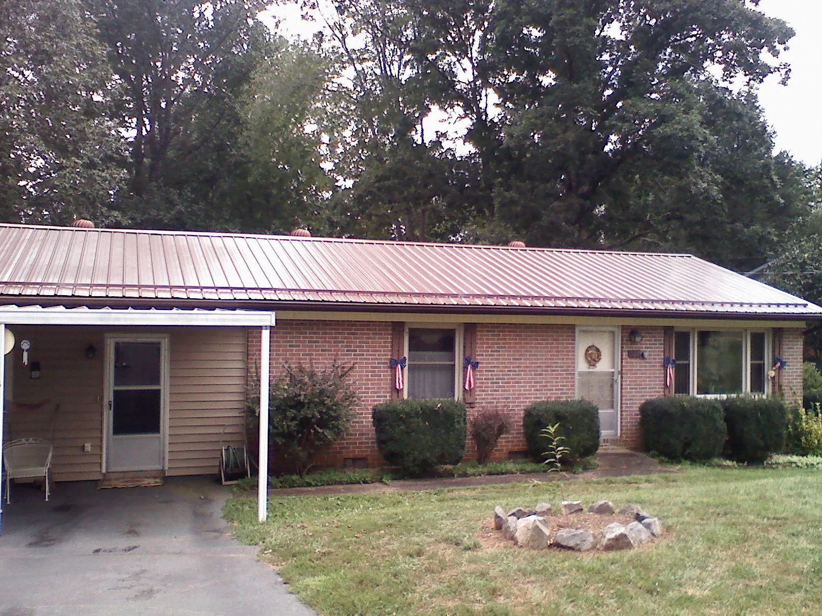 Bronze metal roof and carport on a brick ranch home — Roof Repair work by our crew in Kechi